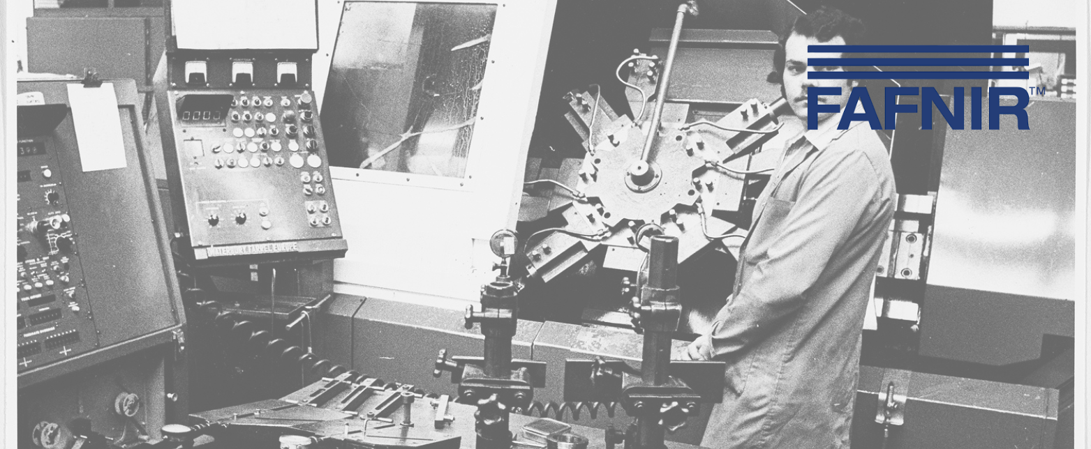 A historic, black and white photo of a Fafnir engineer operating precision machinery in a factory, showcasing the brand's manufacturing legacy.