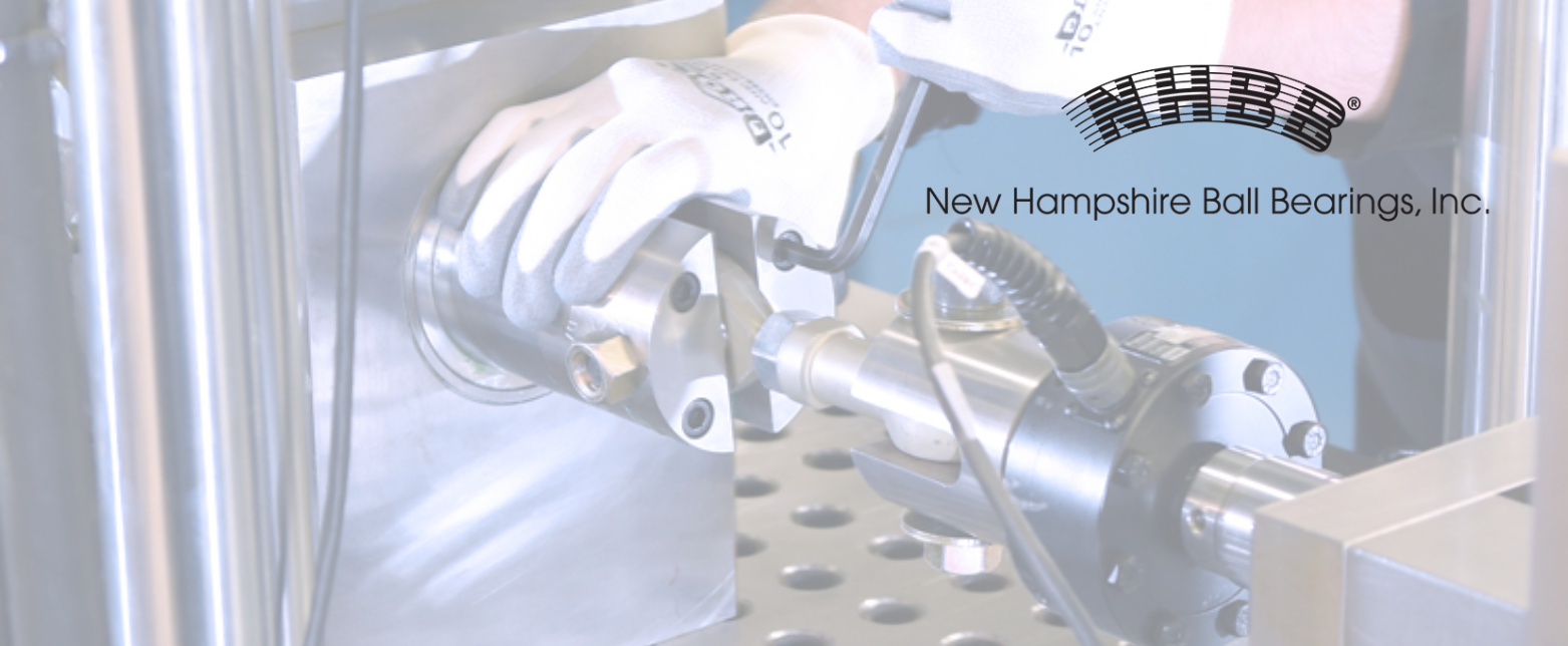 An NHBB engineer tests a high-performance bearing assembly for a demanding aerospace or defense application in a quality control lab.