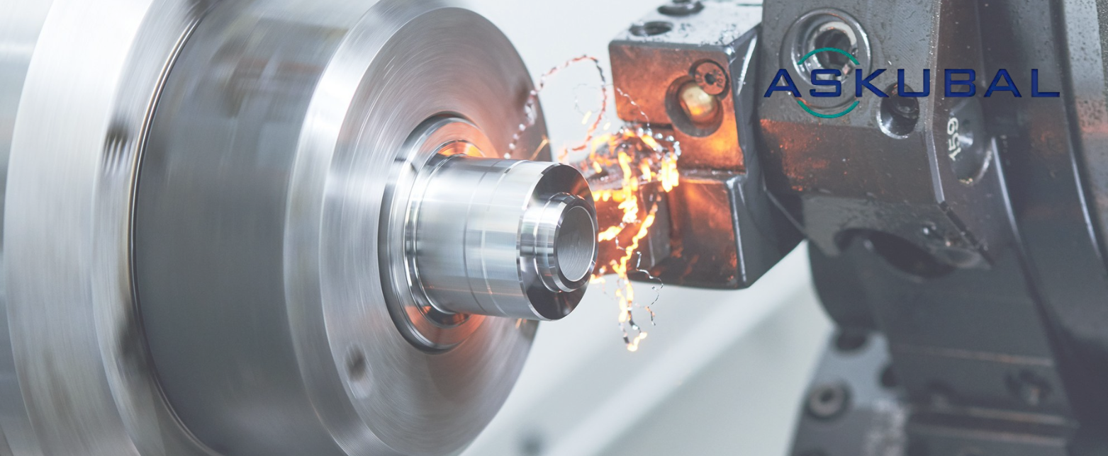 A close-up of the precision manufacturing process for Askubal spherical bearings, with a metal part being machined on a high-speed lathe.